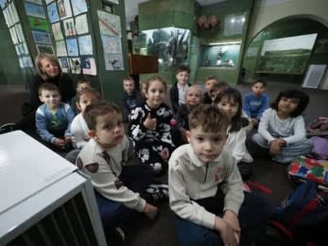 copii explorând diorame și fosile în muzeu