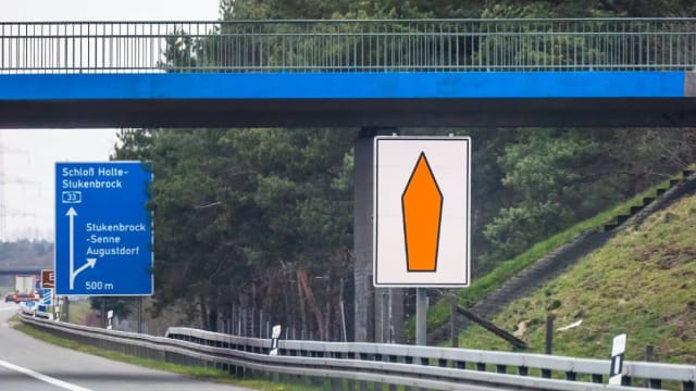 Indicator rutier cu săgeată portocalie pe autostradă