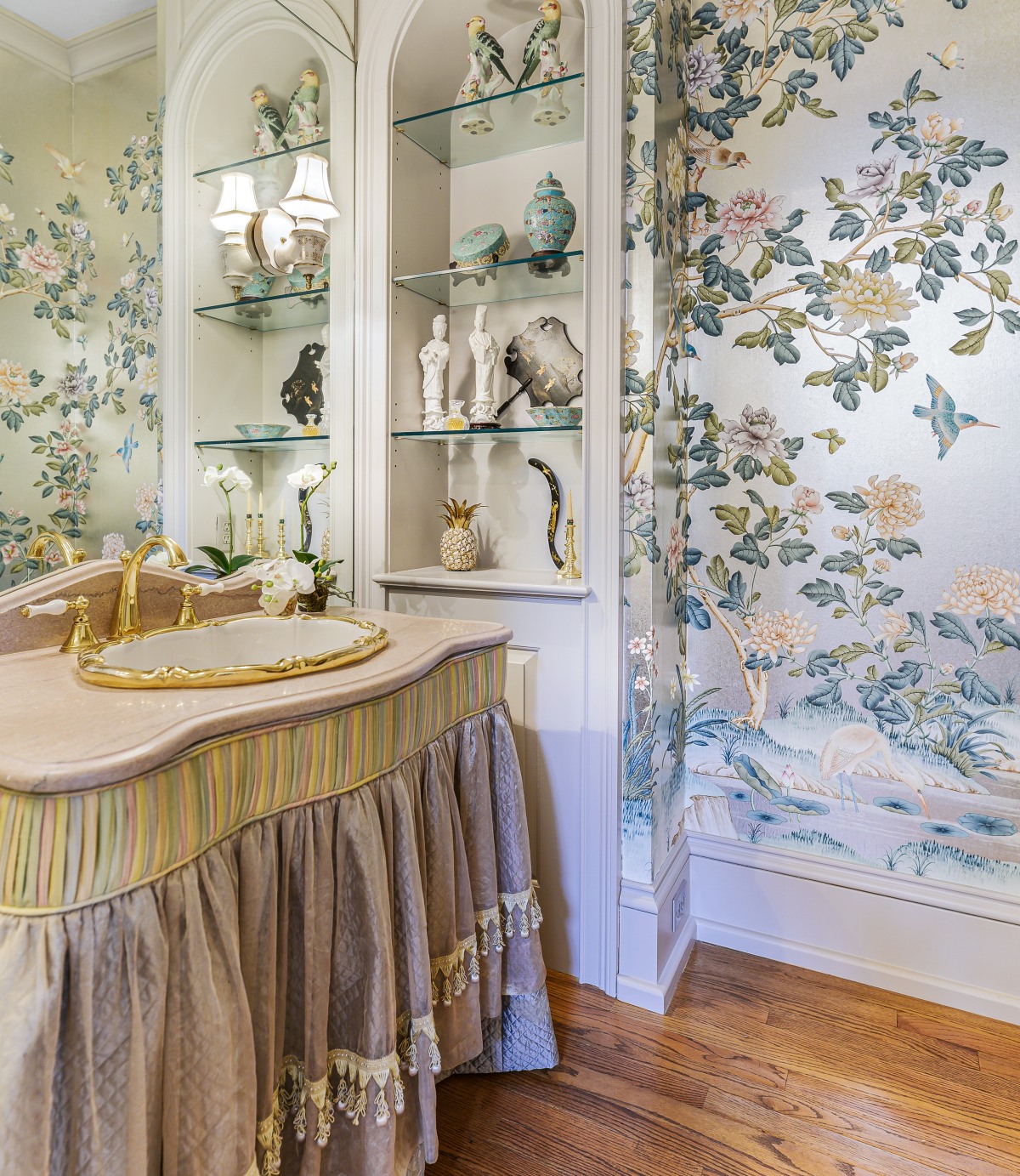 The powder room: gilded sink, hand-painted wallpaper, arched display alcoves