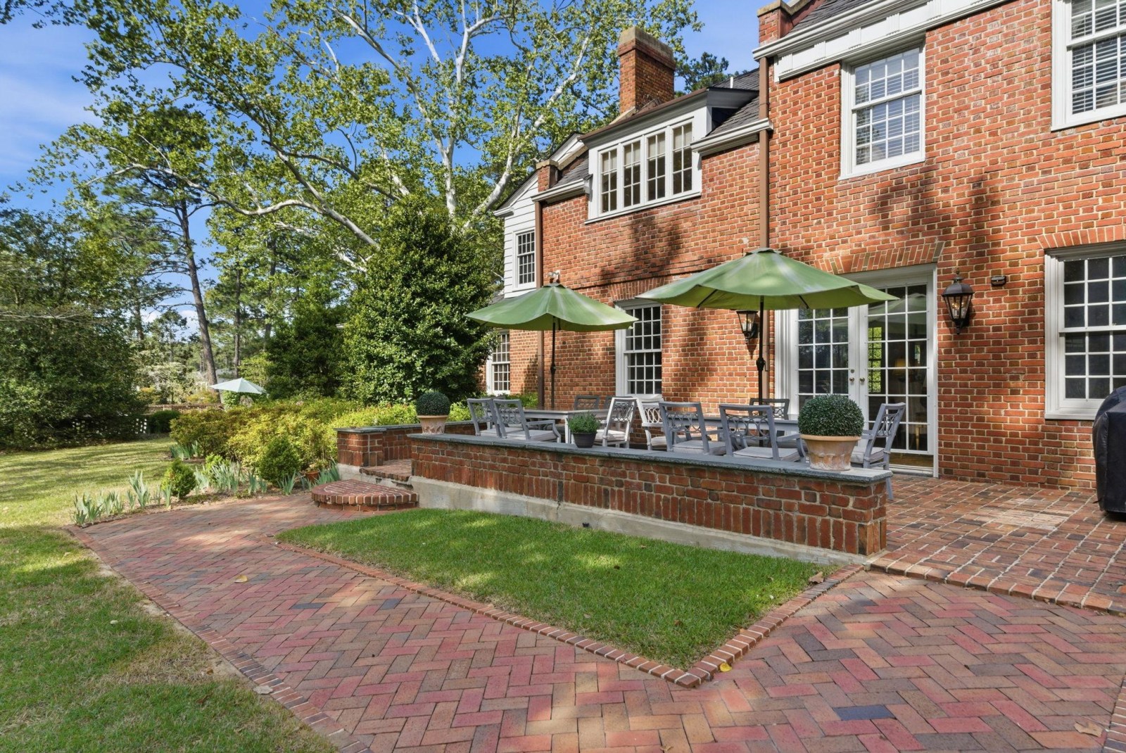 The brick terrace off the kitchen, umbrellas up, set for the afternoon