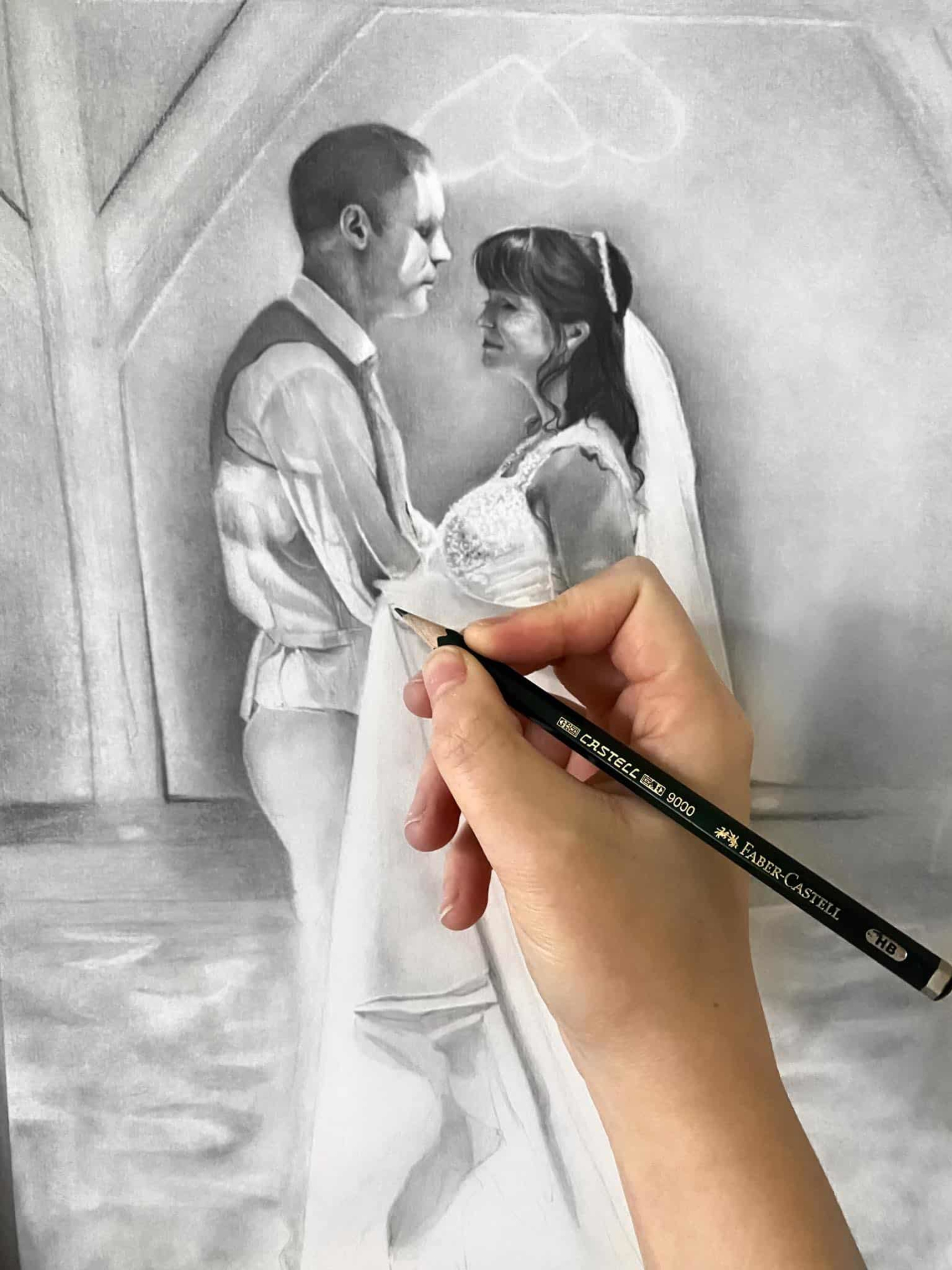 Hand drawing of a bride and groom in a romantic charcoal wedding portrait in progress.