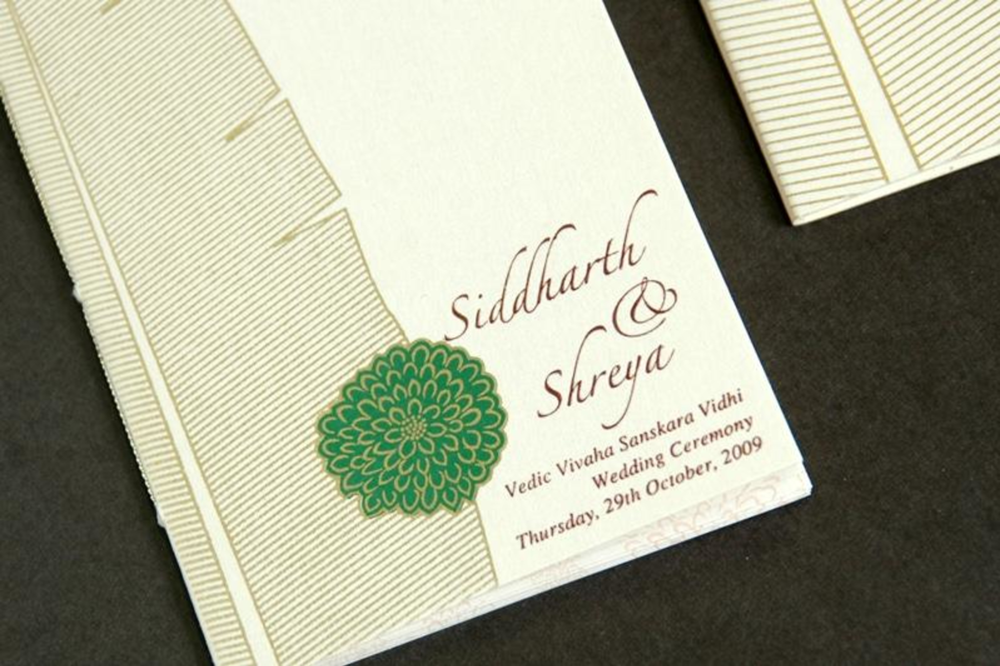 Elegant Indian wedding invitation card with floral motif and scripted couple names.