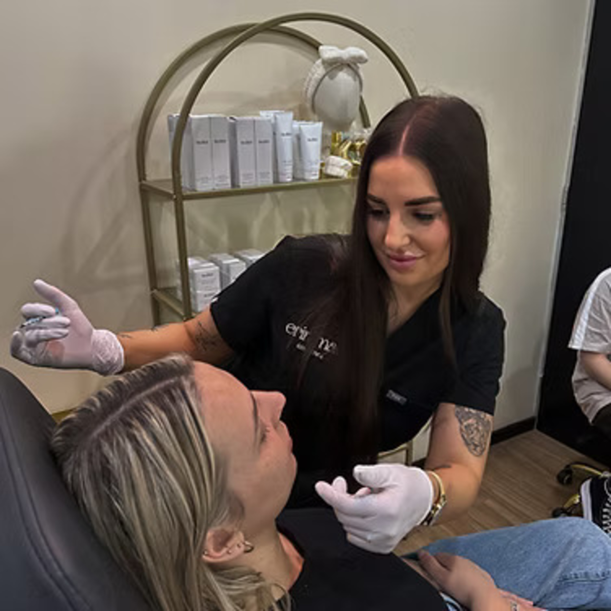 Makeup artist in a salon carefully working on a client’s face during a beauty treatment session.
