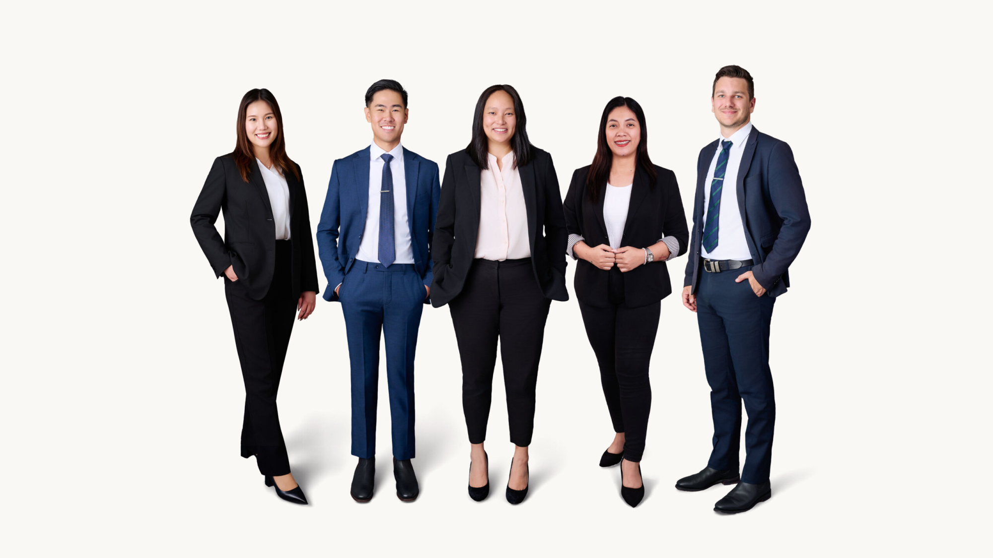 Group portrait of five professionally dressed wedding planning team members standing against a light background.