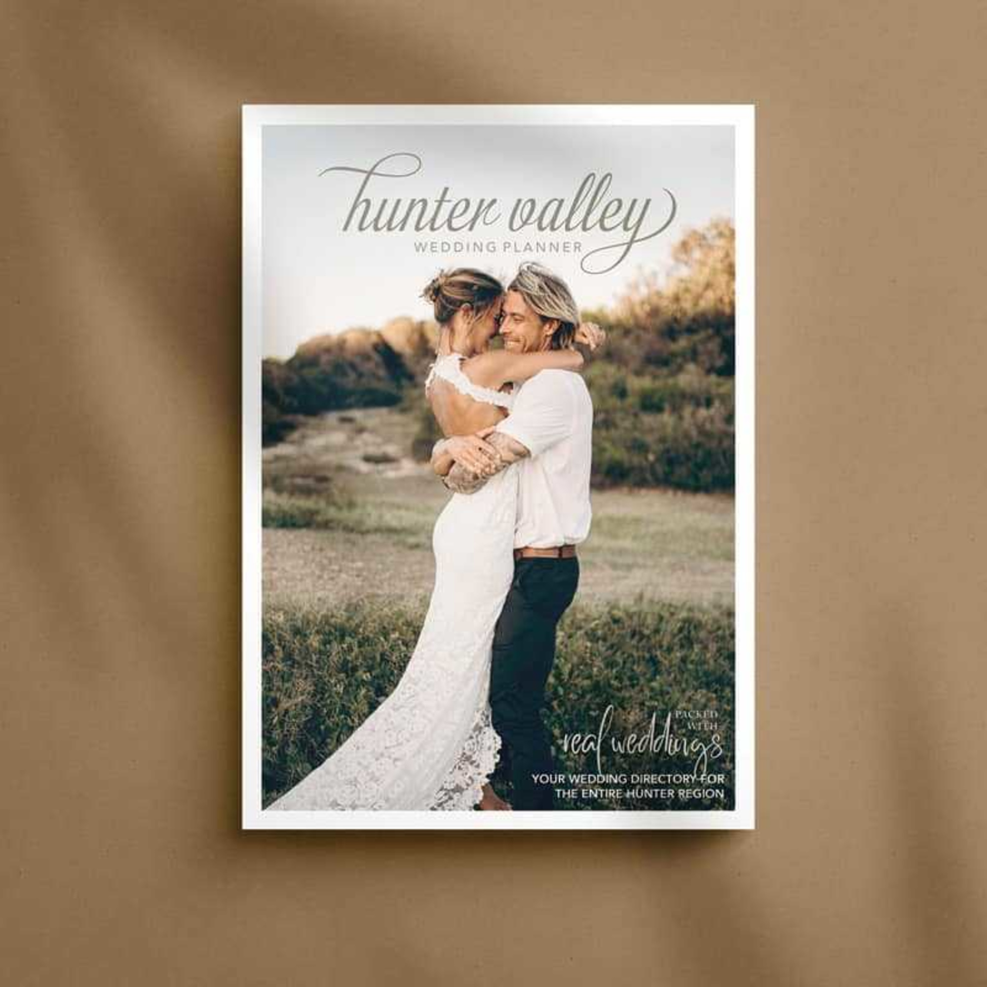 Cover of Hunter Valley Wedding Planner magazine featuring a couple embracing outdoors in a rustic landscape.