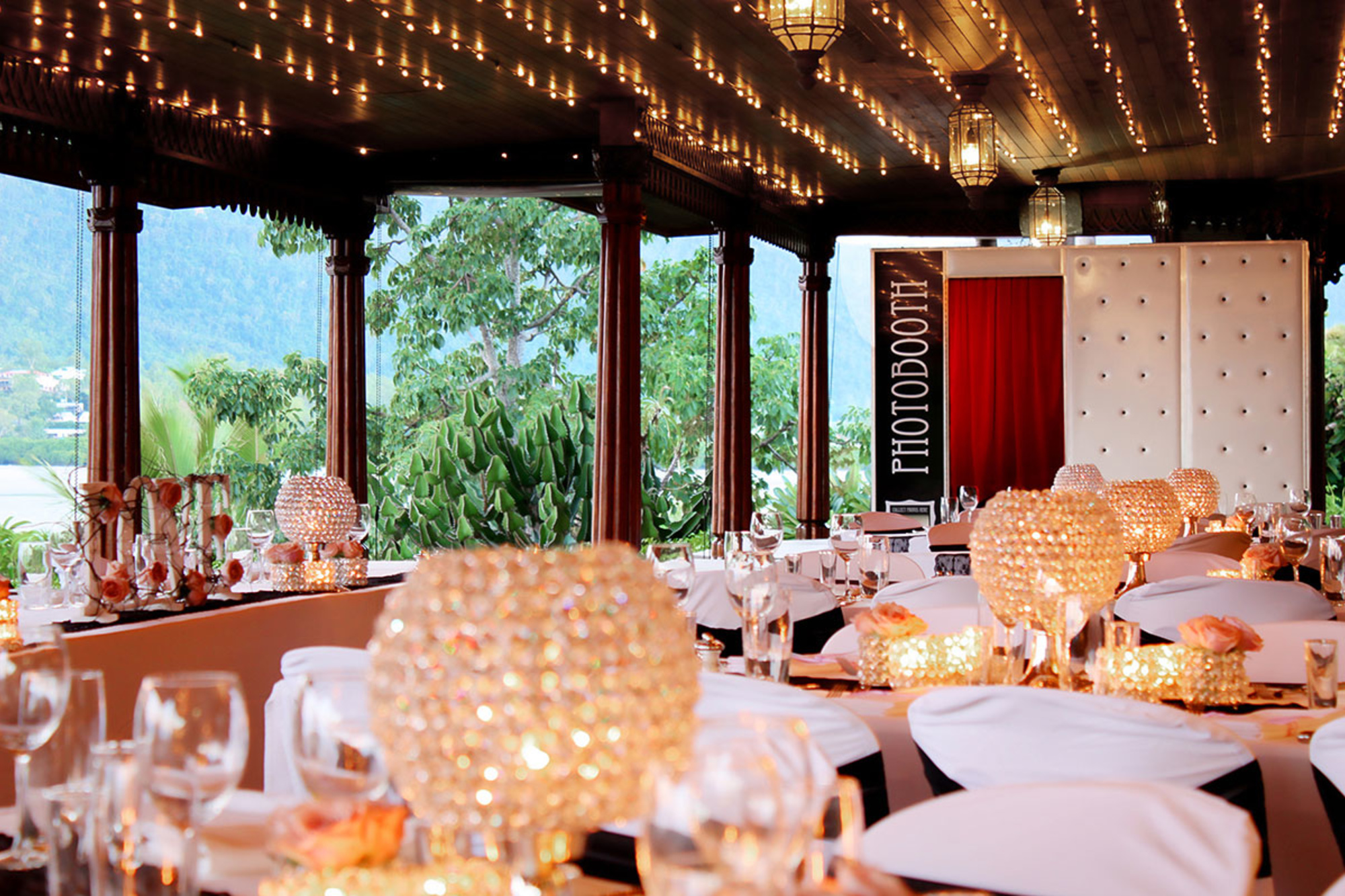 Elegant wedding reception setup with sparkling centerpieces, string lights, and scenic outdoor views.