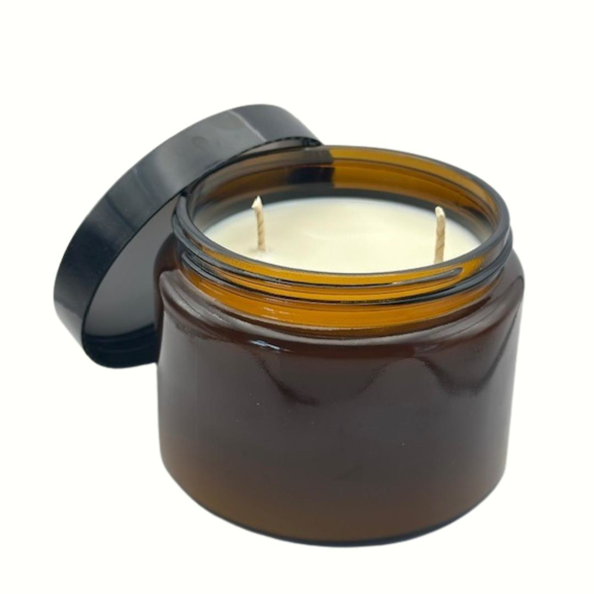 Brown glass jar candle with two wicks and an open black lid on a white background.