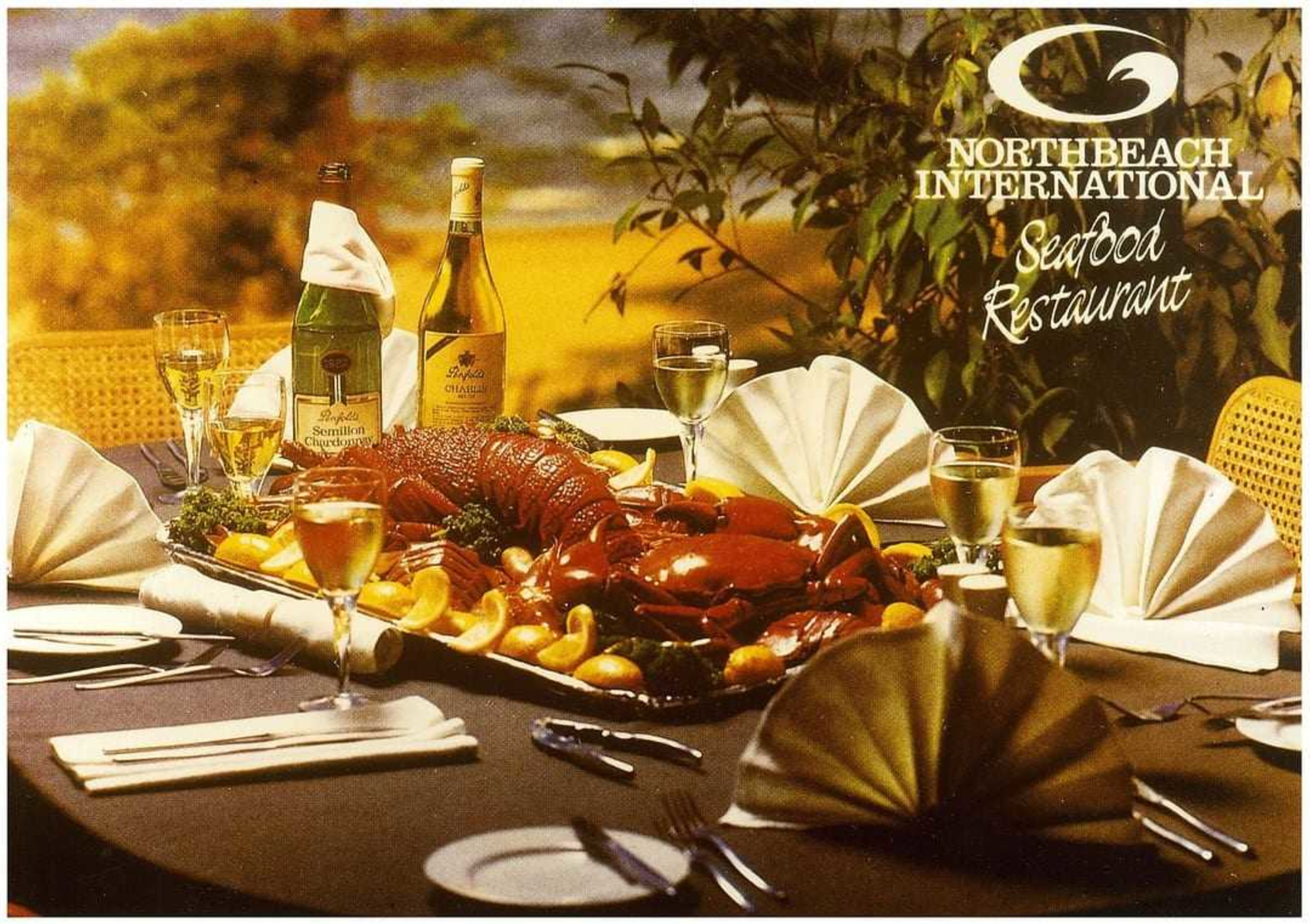 Elegant restaurant table set with seafood platter, wine, and folded napkins for a formal wedding-style dinner.