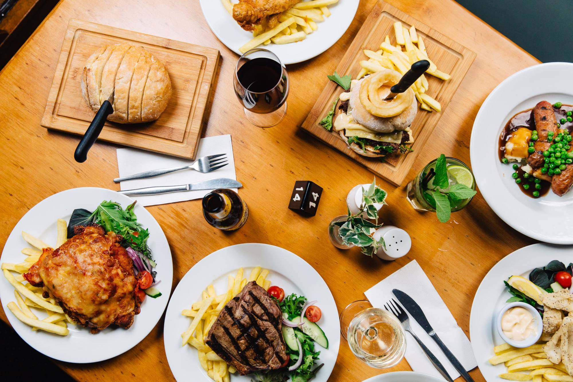 Top view of assorted plated meals and drinks on a wooden table for a wedding reception.