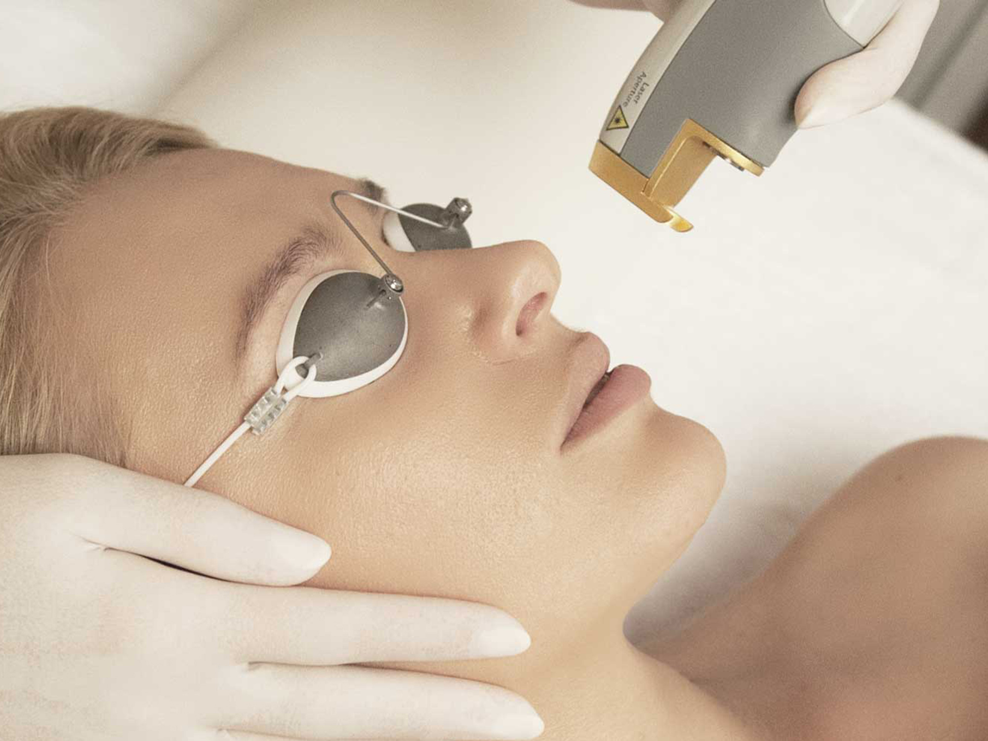 Bride-to-be receiving a professional facial laser treatment wearing protective eye shields.