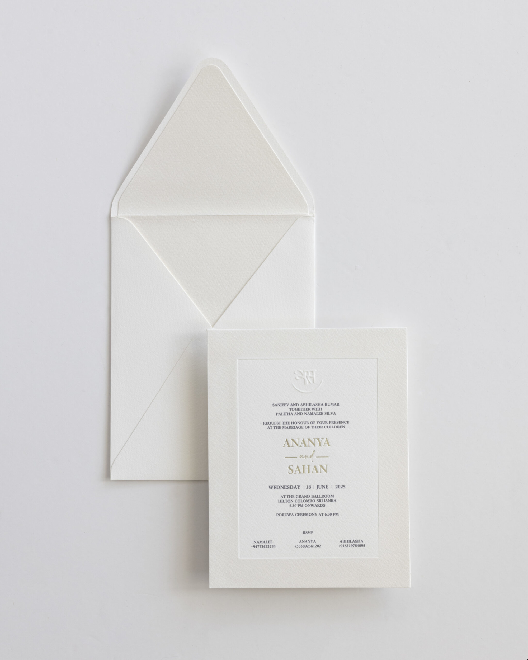 Minimalist white wedding invitation card with matching envelope laid on a light background.