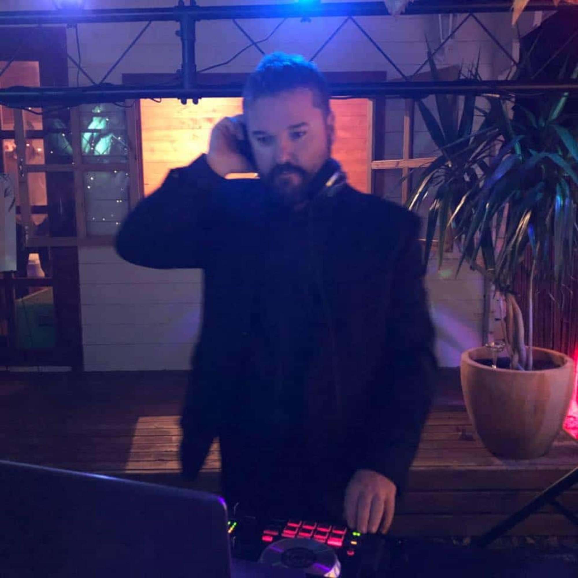 DJ mixing music at an evening wedding reception under colorful lights