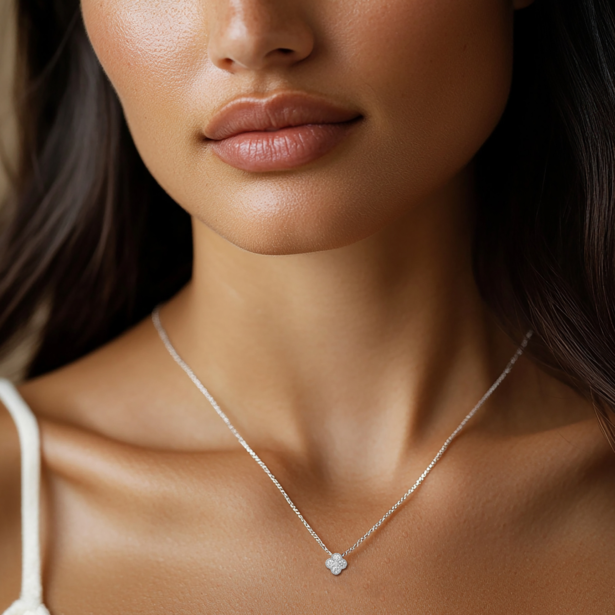 Close-up of a bride wearing a delicate silver pendant necklace on her wedding day.