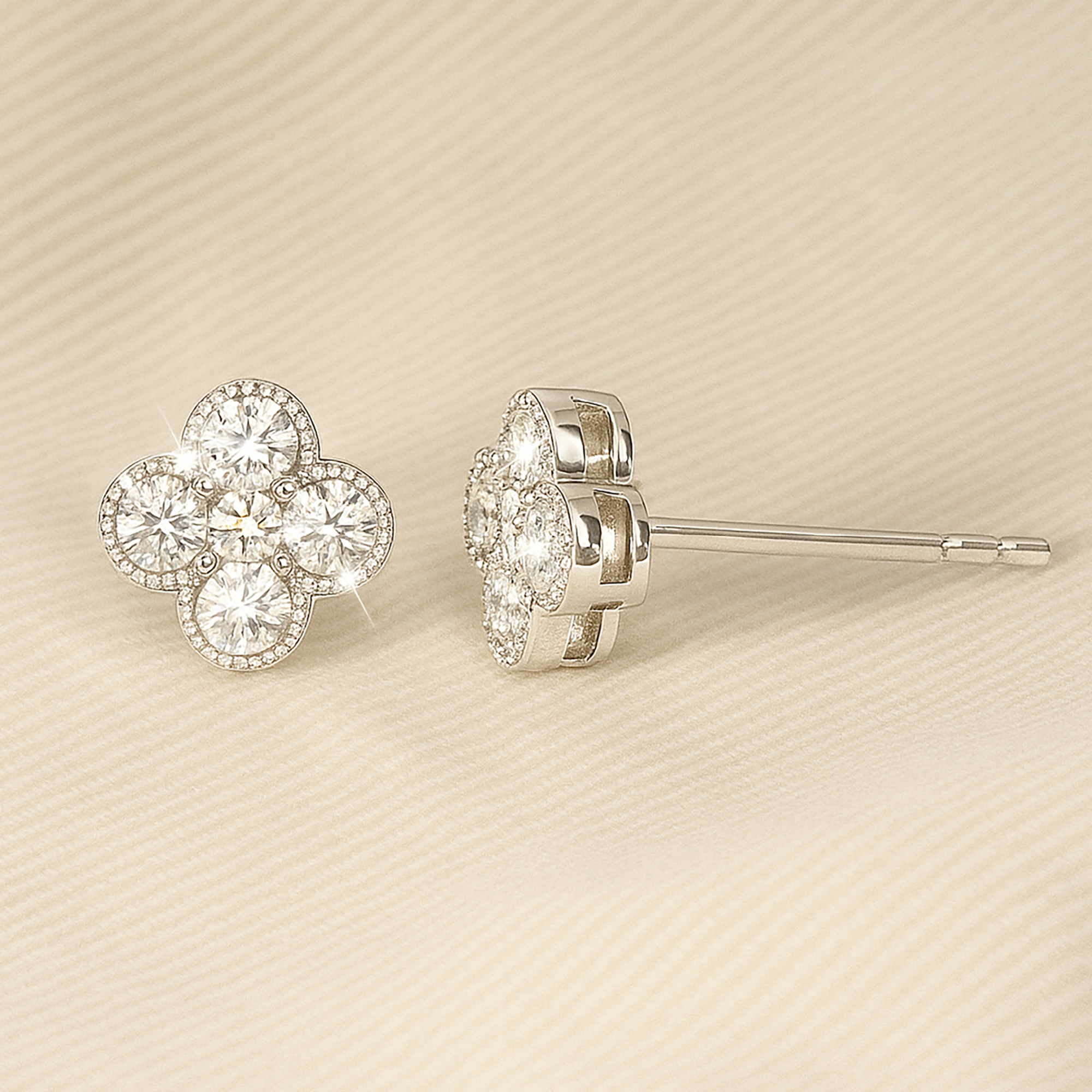 Close-up of sparkling floral diamond stud earrings on a soft beige background.