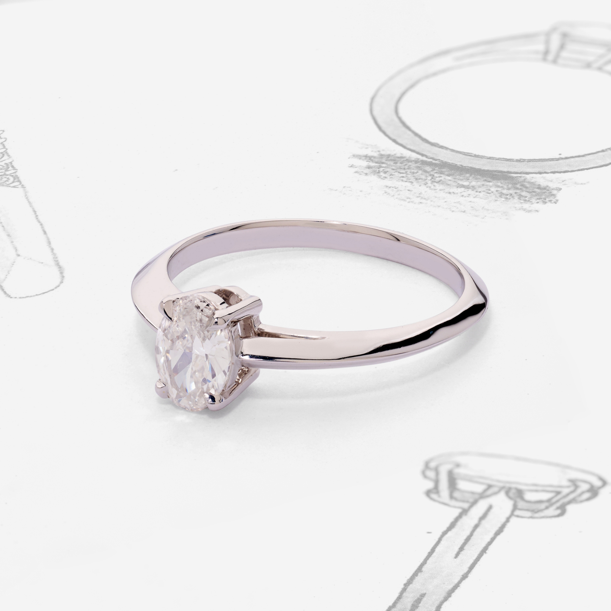 Elegant solitaire engagement ring displayed on a white background with sketch drawings of ring designs.