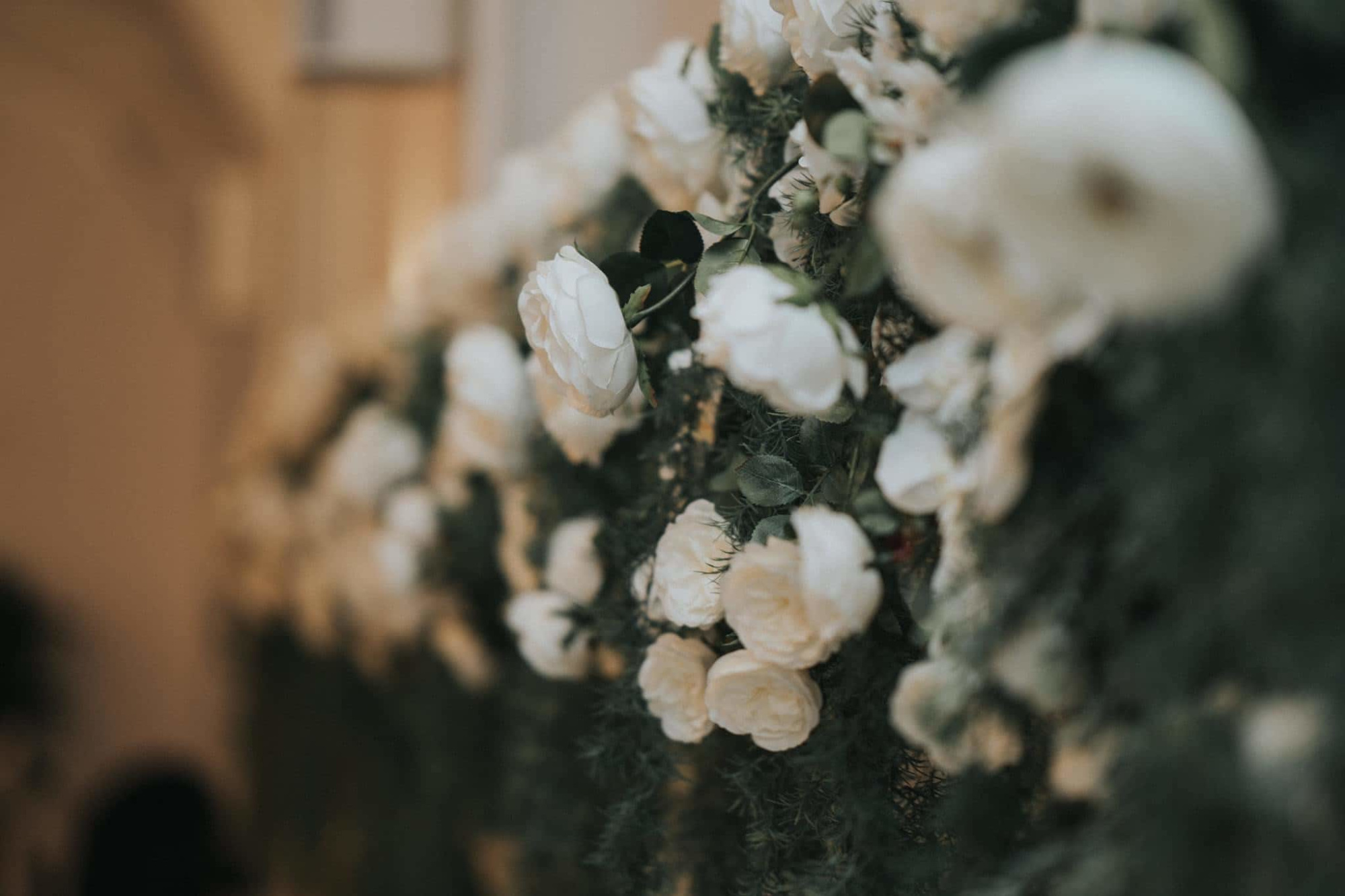 Close-up of a romantic white rose flower wall used as wedding decor.
