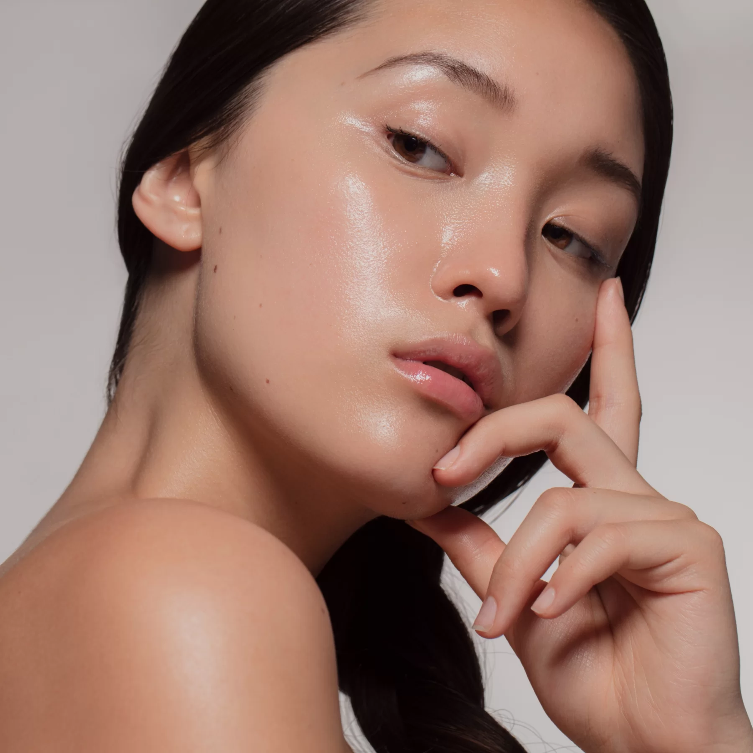 Close-up bridal beauty portrait with glowing natural makeup and soft nude lips.