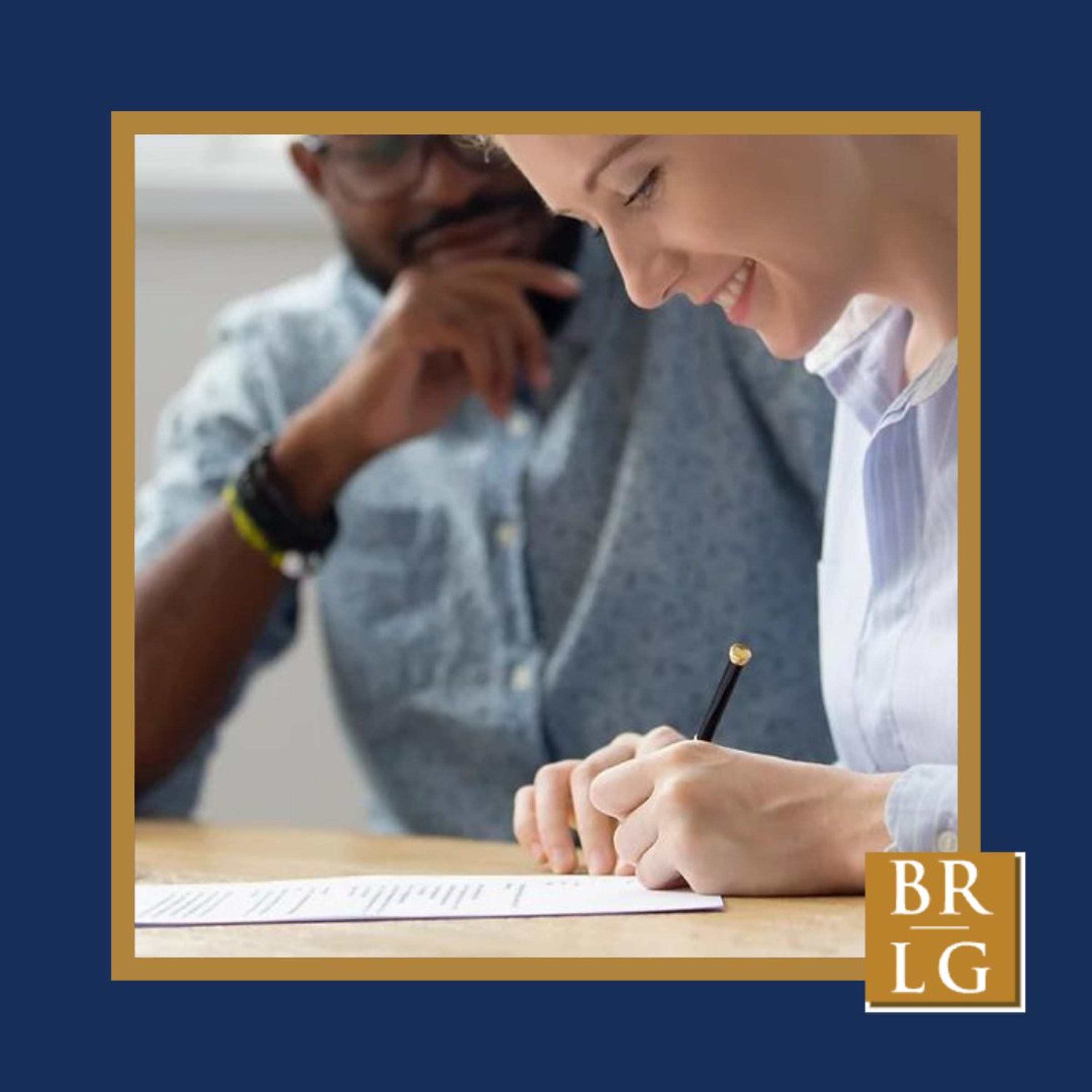 Couple reviewing and signing a wedding planning or vendor contract at a desk.