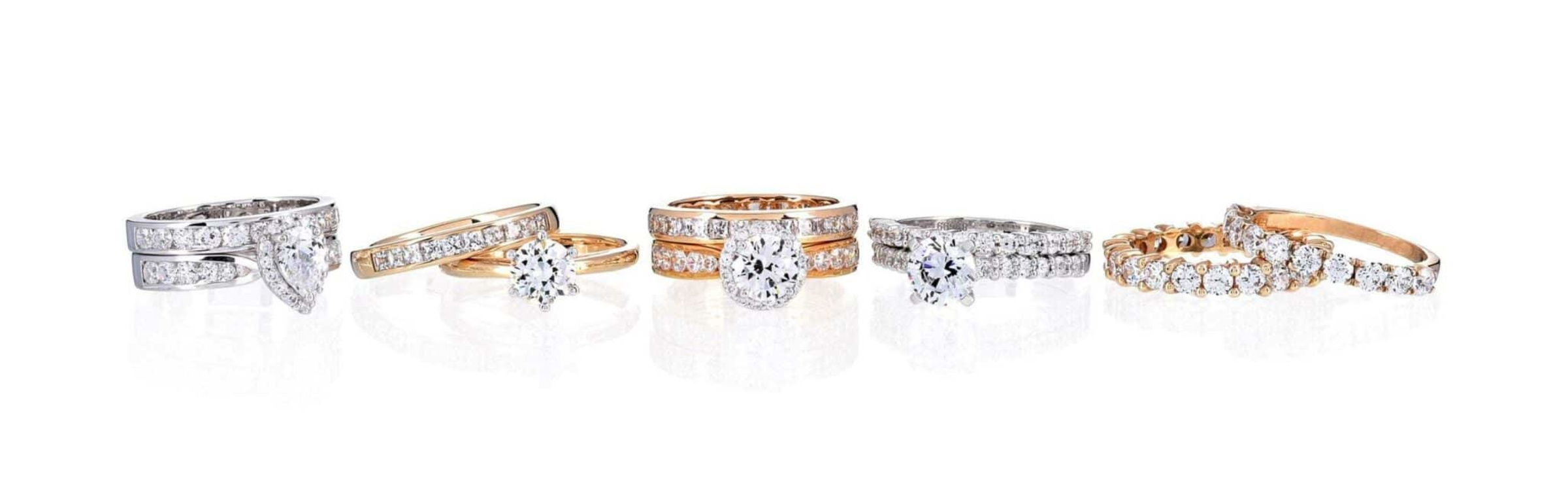 Assorted gold and white gold diamond engagement and wedding ring sets displayed on a white background.
