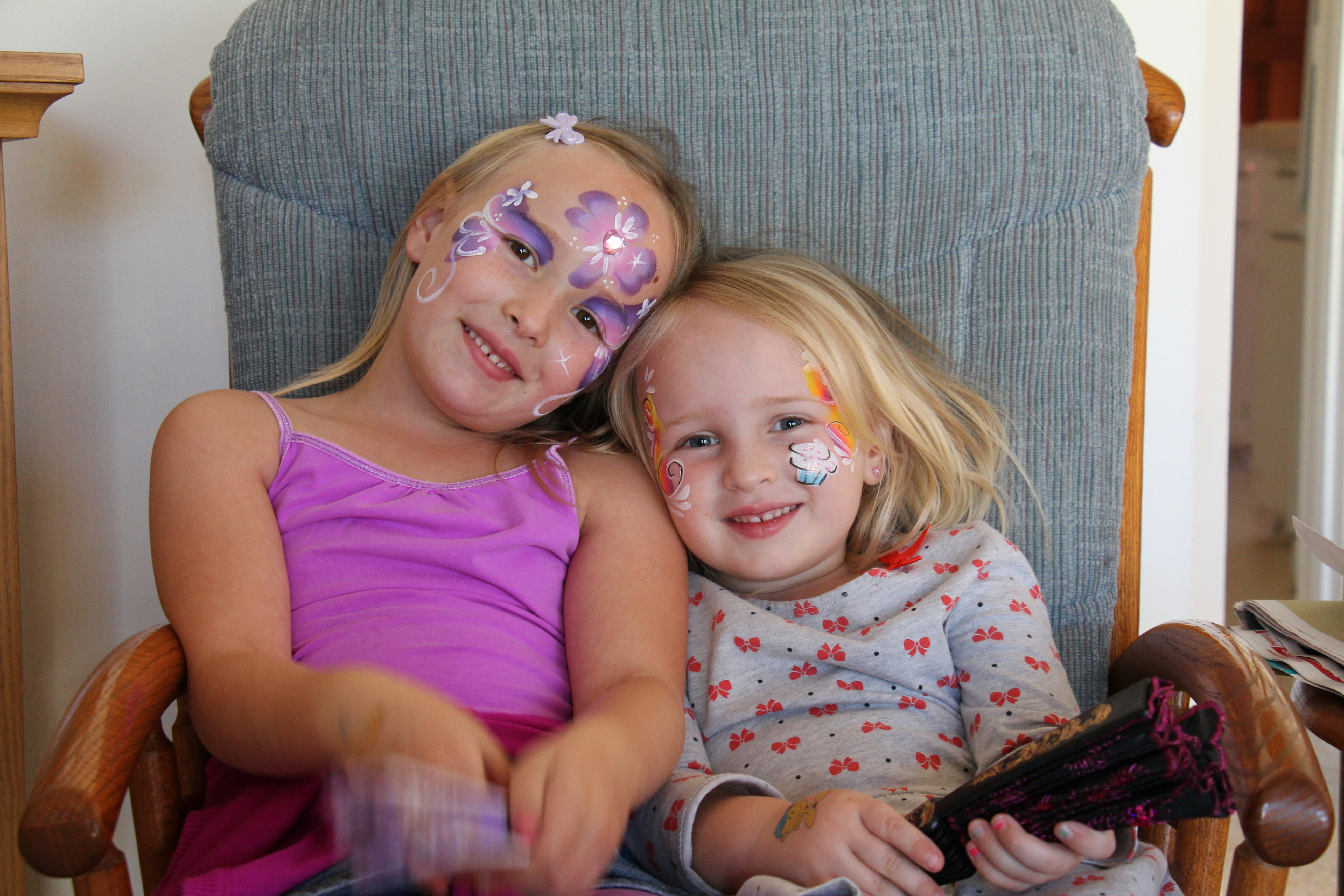 Two children sitting together with face paint on