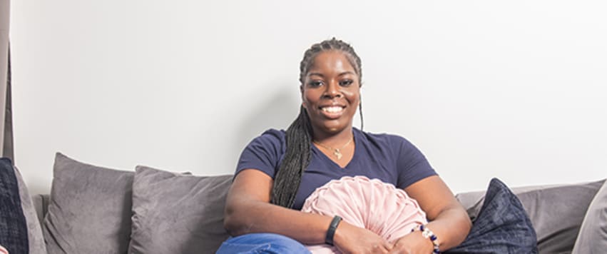Lady sitting on sofa holding cushion
