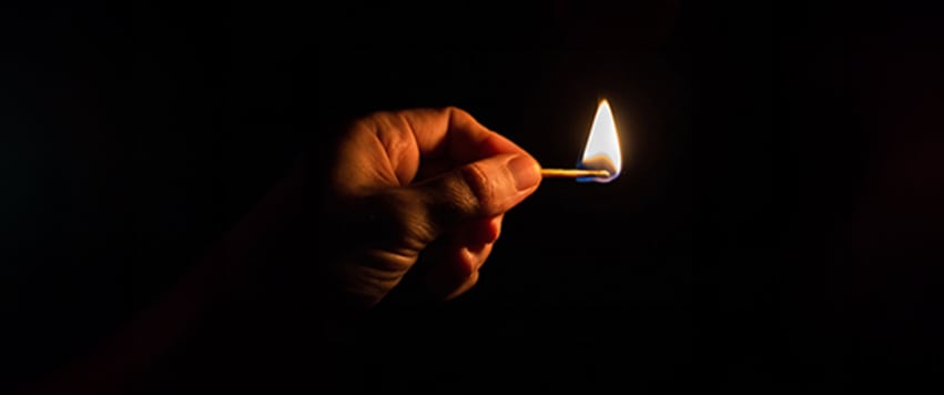 someone holding a lighted match