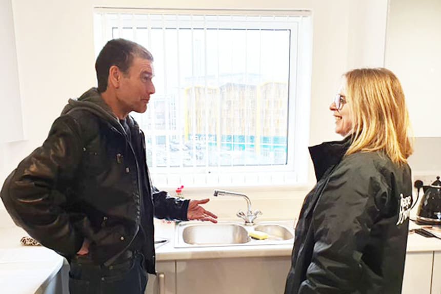 man and woman talking in kitchen