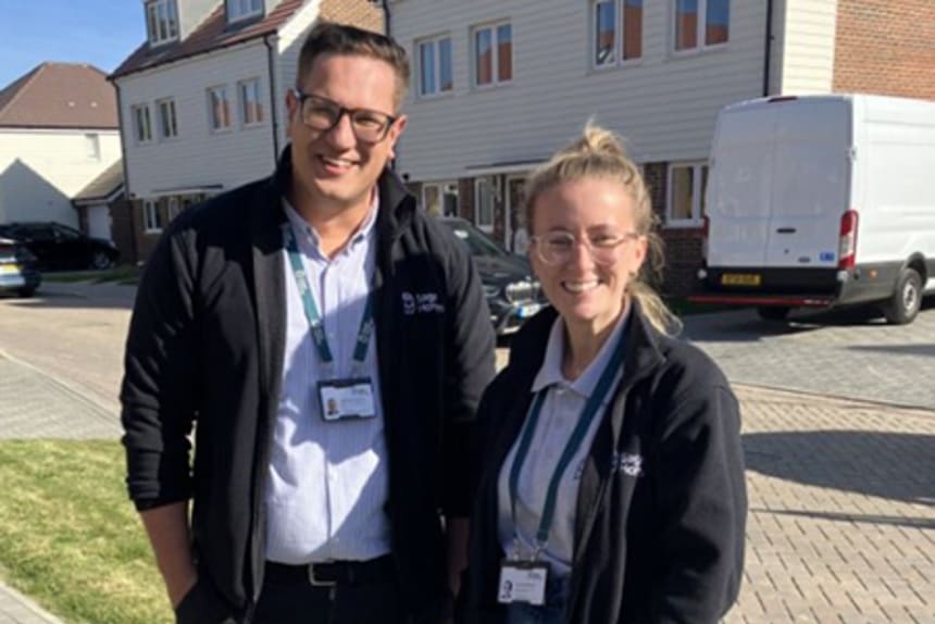 A smiling man and woman in Sage Homes uniform