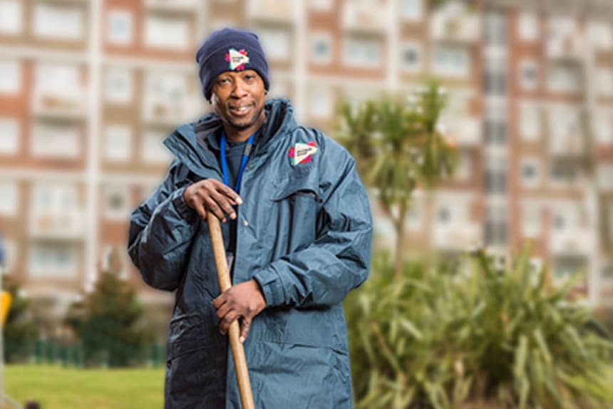 smiling man on estate holding broom