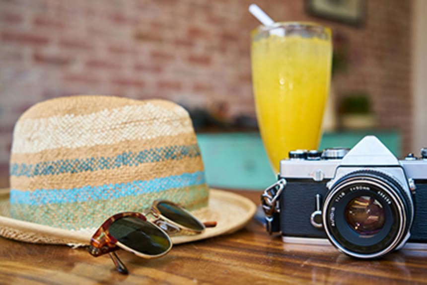 Hat drink and camera on a table