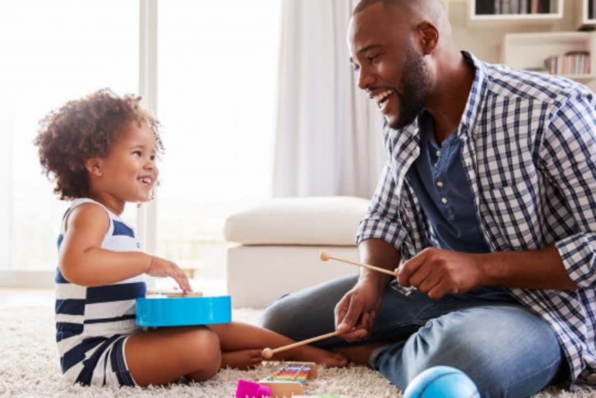 Man and child playing on musical instruments