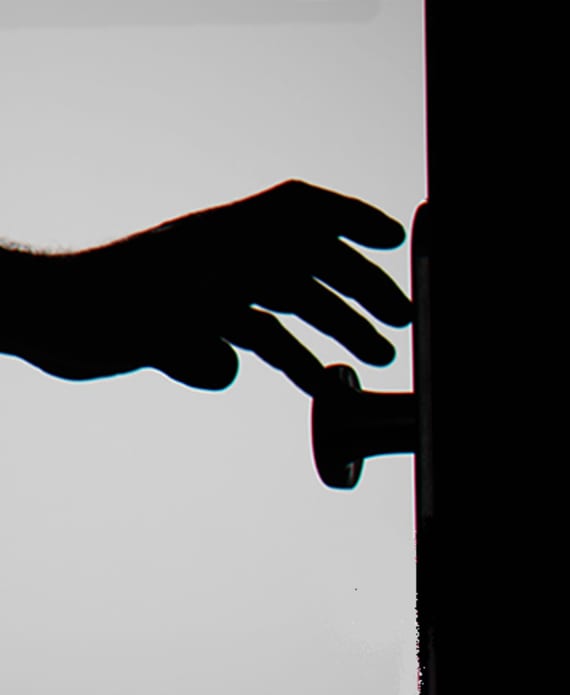 Silhouette of someone's hand on doorknob