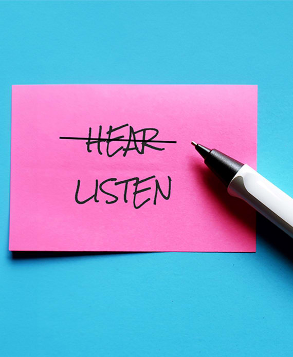 post-it note saying 'hear, listen'