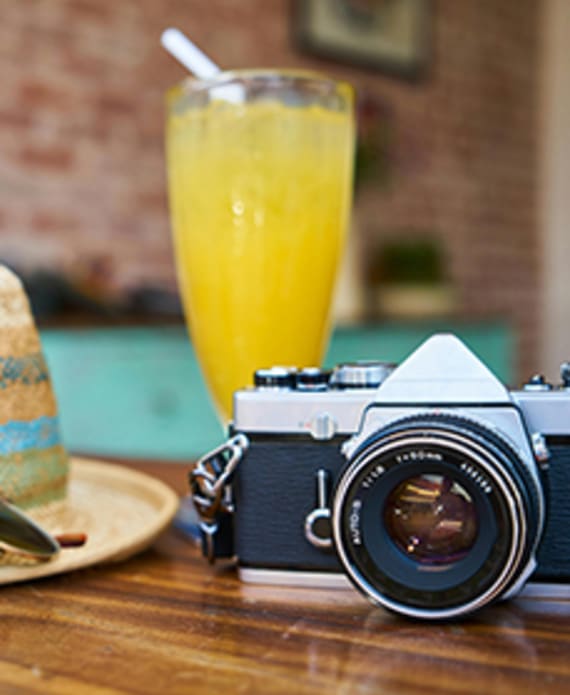 Hat drink and camera on a table