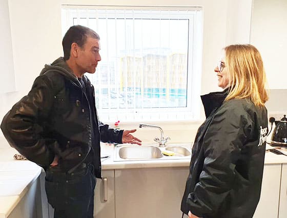 man and woman talking in kitchen