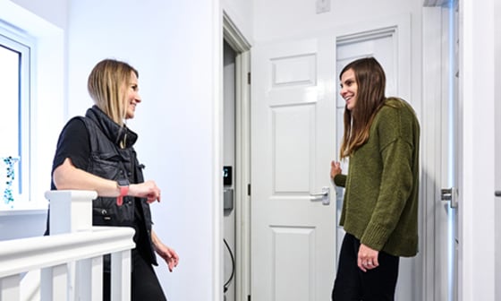 Two young ladies talking in hallway