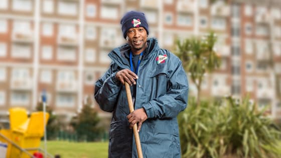 smiling man on estate holding broom