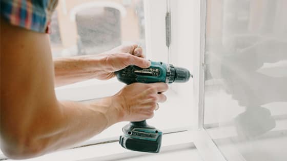 Someone using a drill near a window