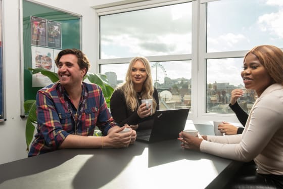 Two women and man smiling at table