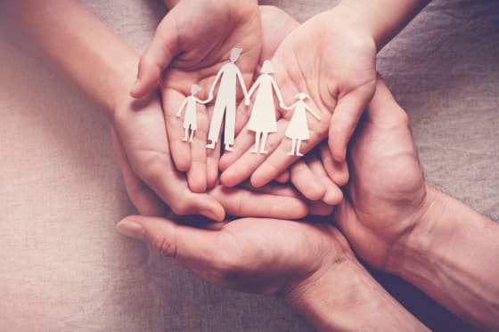 Hands holding an origami family