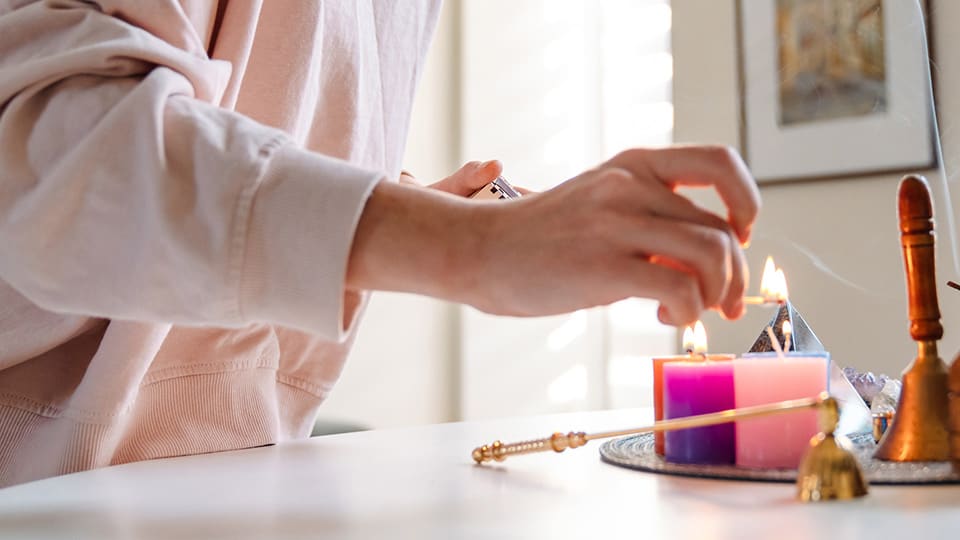 Female hand, lighting candles carefully at home
