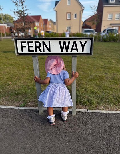 little girl under road sign