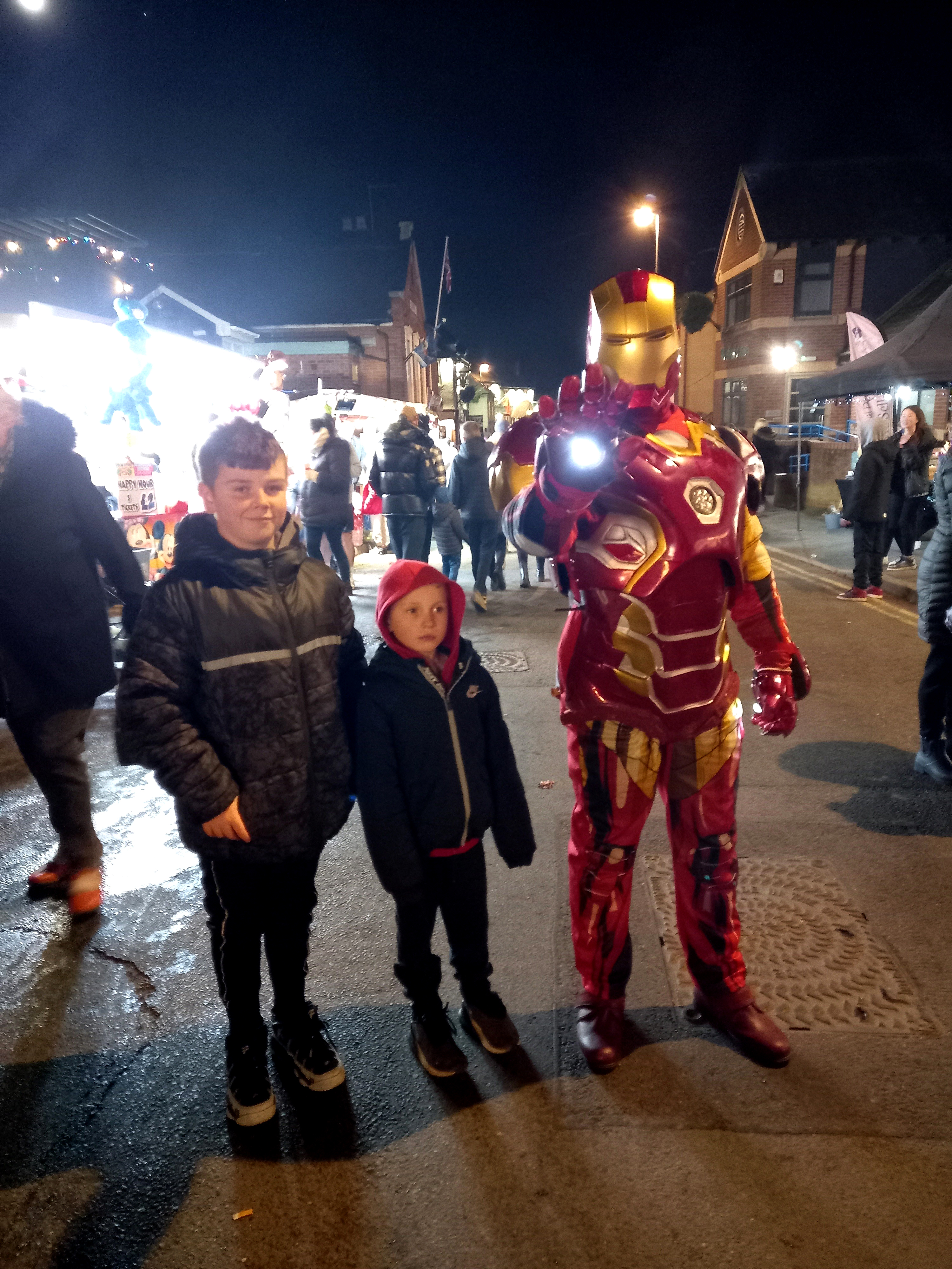 A family with kids at a community Christmas event (with Iron Man)