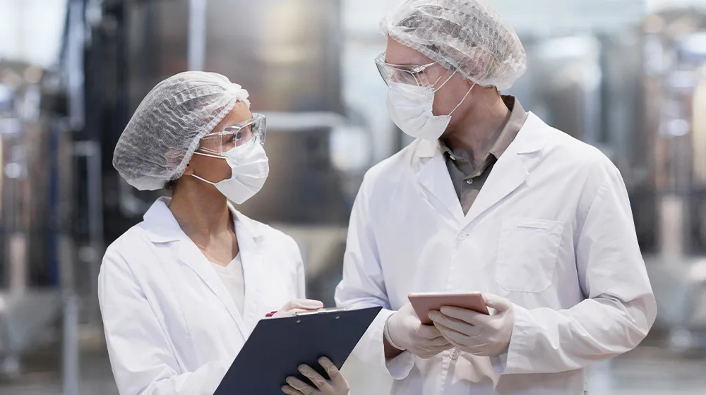 hydrachem factory workers with hairnets, masks and clipboards