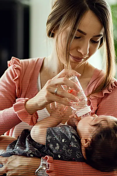 woman feeding baby with a bottle sterilised by hydrachem oasis sterilising tablets