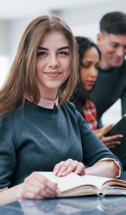 A girl from the NJ Marketing team is looking at a camera.