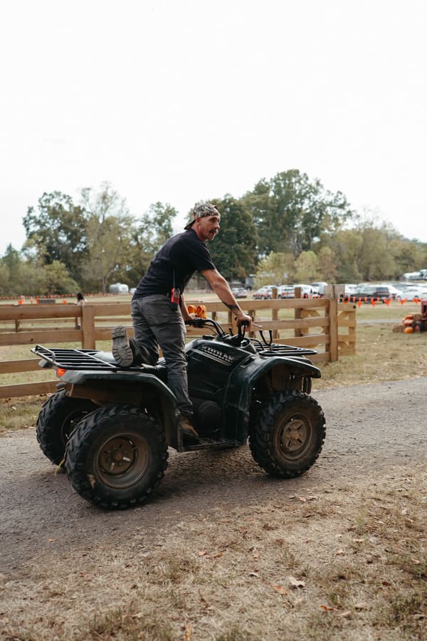 Farmhand riding an ATV along the fence line