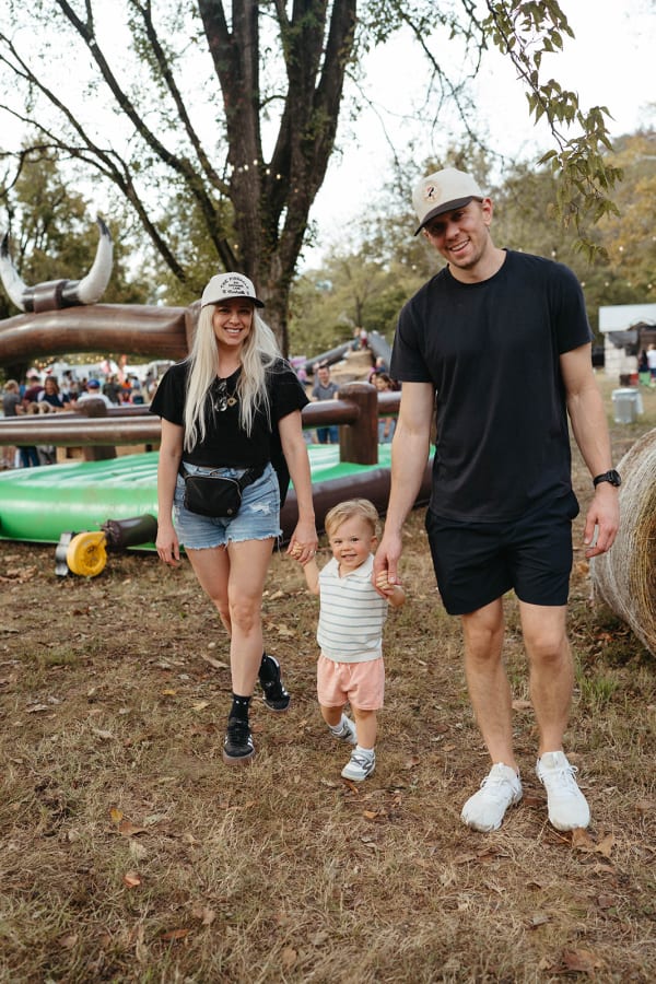 Parents walking hand in hand with their toddler
