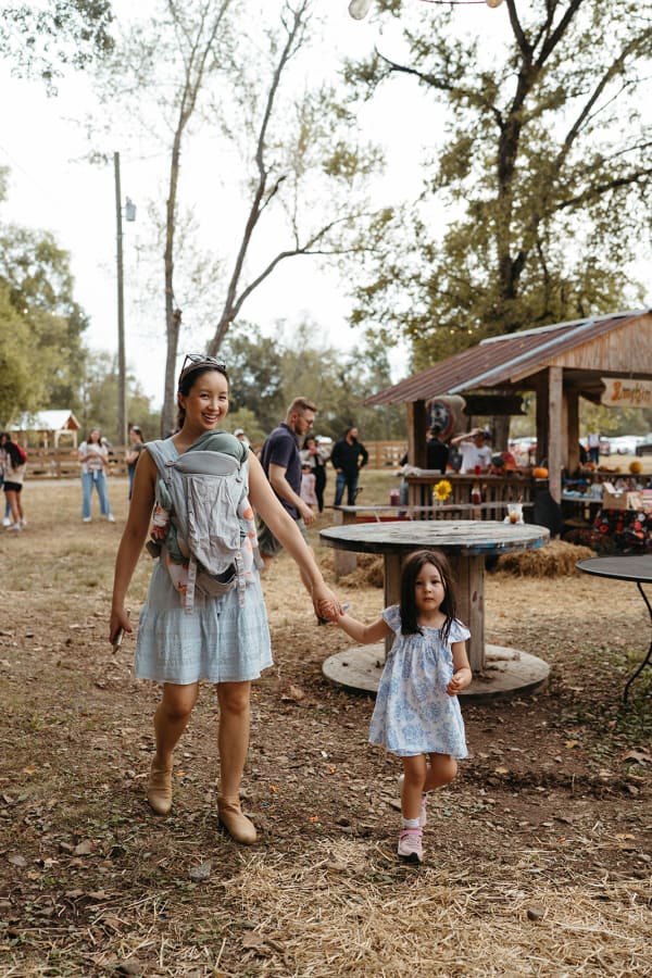 Mom wearing her baby, walking the grounds with her daughter