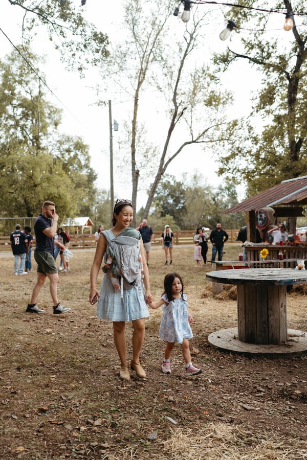 Mom wearing her baby, walking the grounds with her daughter